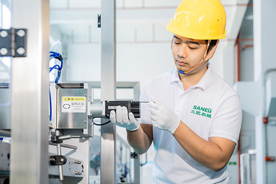 technician checking the components of the coffee filling machine during assembly