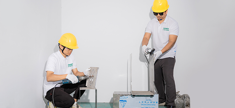 a couple of Saneu personnel crafting the aluminum parts of the filling machine