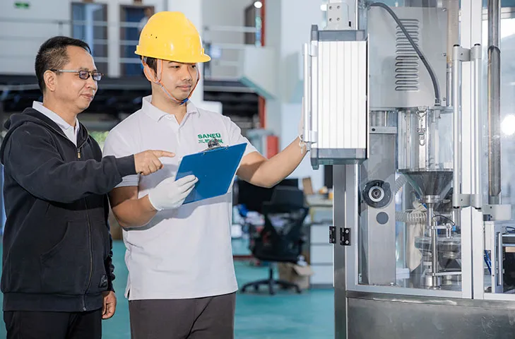 a senior employee guiding another employee on what to check on the checklist 2