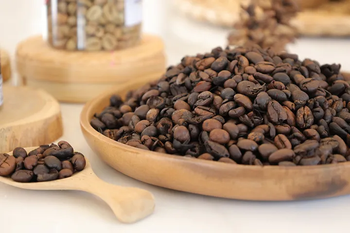 ground coffee beans in a wooden plate and spoon