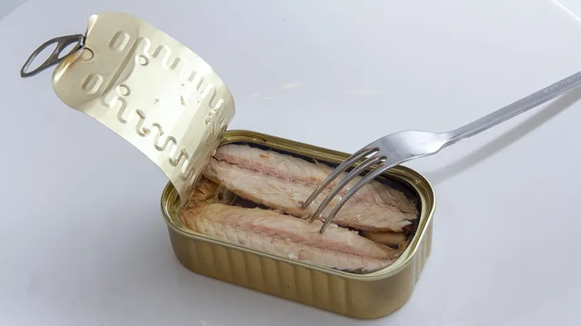 an open can of deboned fish in brine with a fork on top